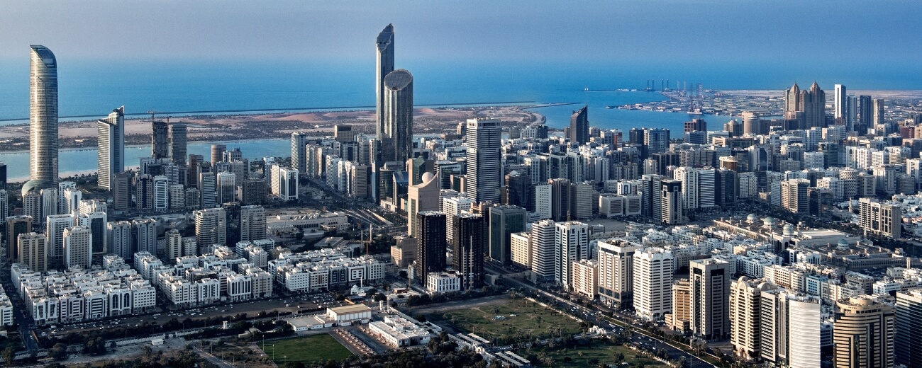 Panoramic view of Abu Dhabi’s city skyline with high-rise towers and coastline in the background