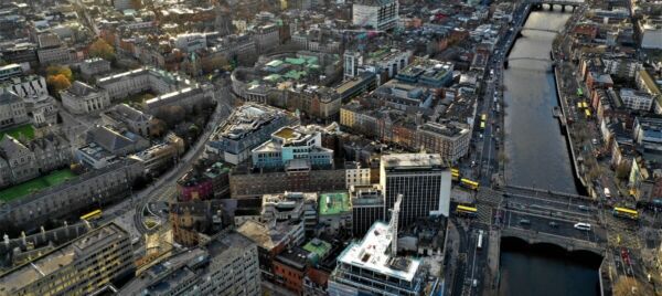 Wide aerial shot of Dublin city with the River Liffey, bridges, and surrounding buildings.