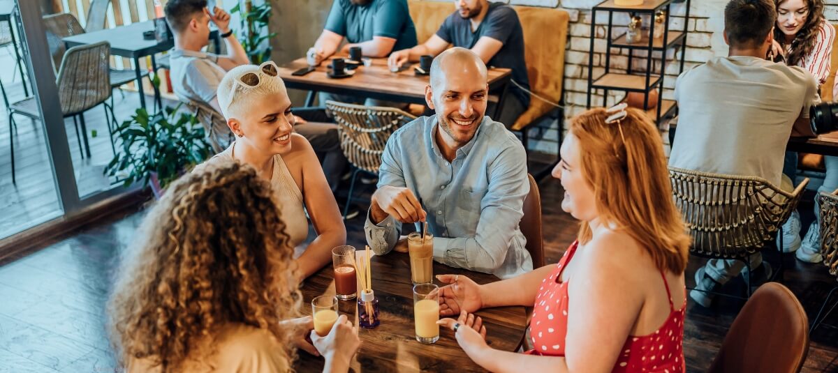 Group of friends and expats enjoying drinks together in a European café, reflecting the social lifestyle in the best cities to move to in Europe. Group of friends and expats enjoying drinks together in a European café, reflecting the social lifestyle in the best cities to move to in Europe.