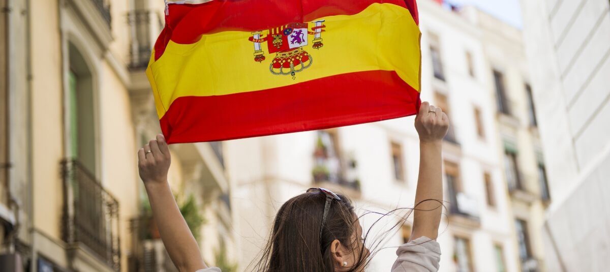 Brit holding Spanish flag after moving from the UK to Spain in 2025 Brit holding Spanish flag after moving from the UK to Spain in 2025
