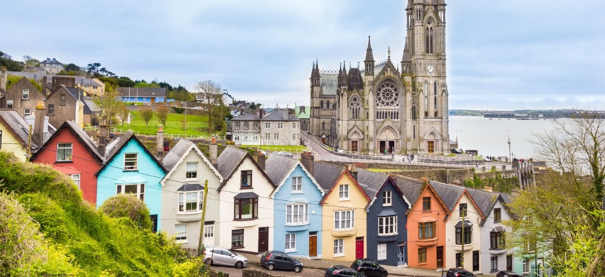 A row of colourful homes leading to the majestic St. Colman’s Cathedral in Cobh, Ireland, a perfect blend of coastal and historic Irish scenery. A row of colourful homes leading to the majestic St. Colman's Cathedral in Cobh, Ireland, a perfect blend of coastal and historic Irish scenery.