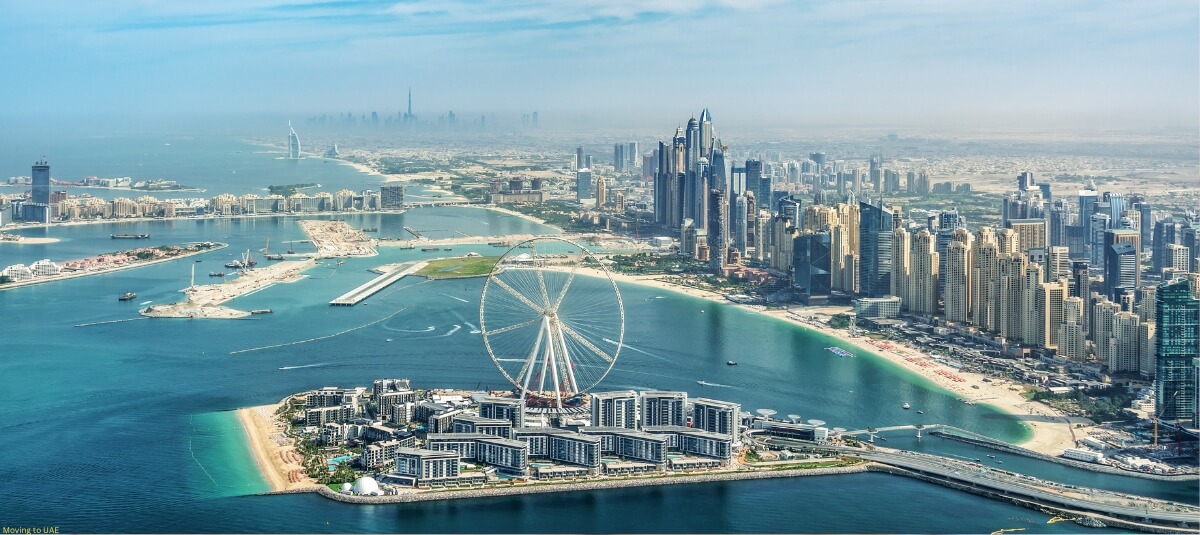 Aerial view of Dubai’s modern skyline with a prominent Ferris wheel on the waterfront. Aerial view of Dubai’s modern skyline with a prominent Ferris wheel on the waterfront.