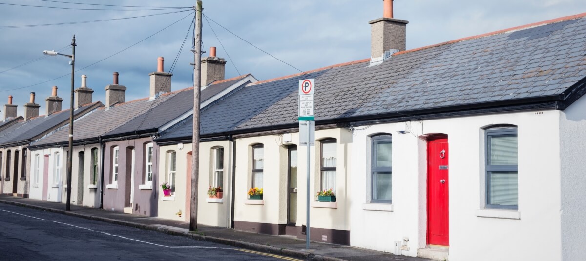 Row of traditional terraced cottages in Dublin with colourful doors and window flower boxes.