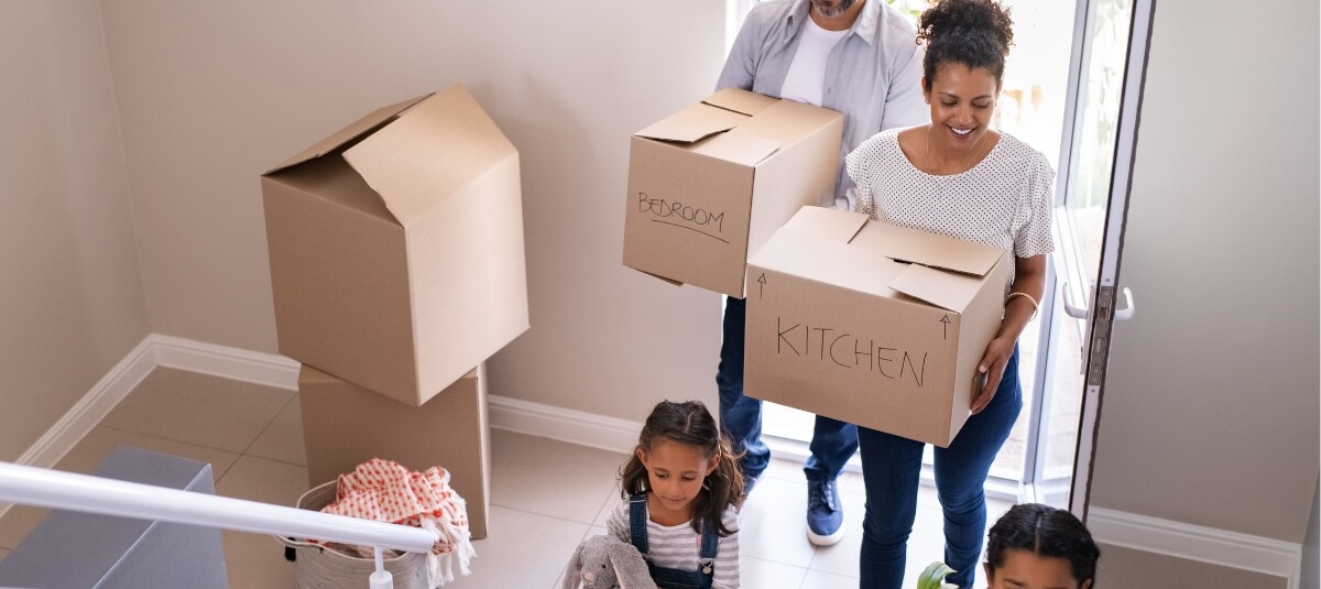 Family carrying moving boxes into a new home after moving to Spain from the UKFamily carrying moving boxes into a new home after moving to Spain from the UK