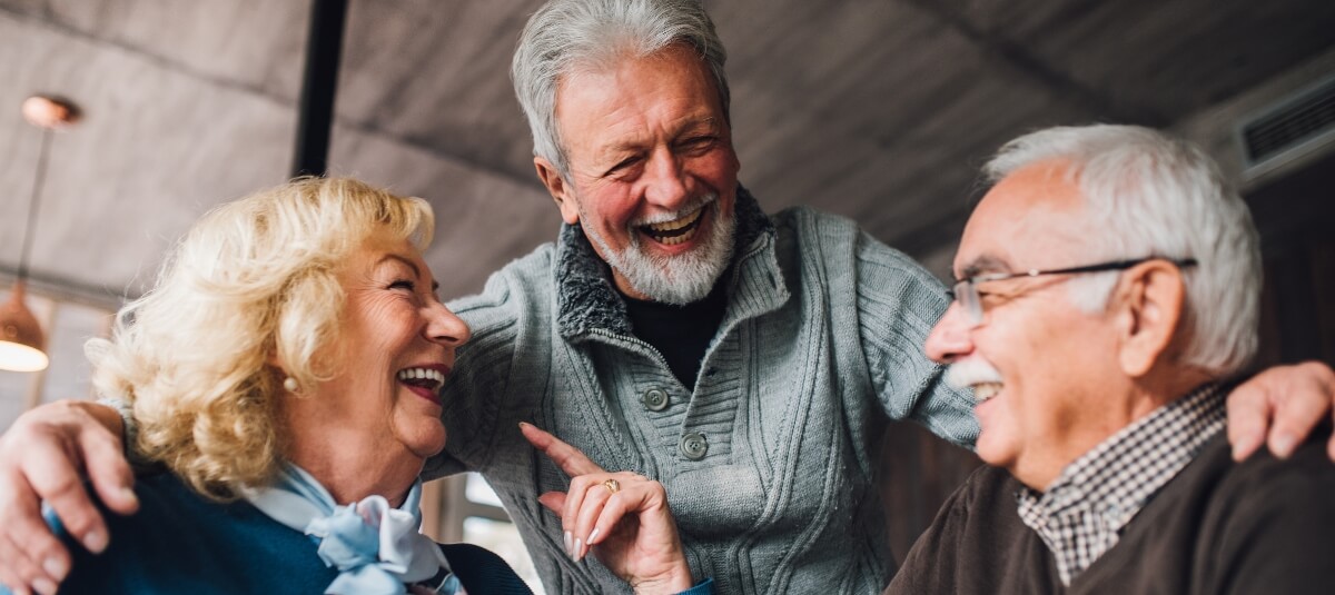 Happy retired UK expats laughing and socialising in their new home overseas