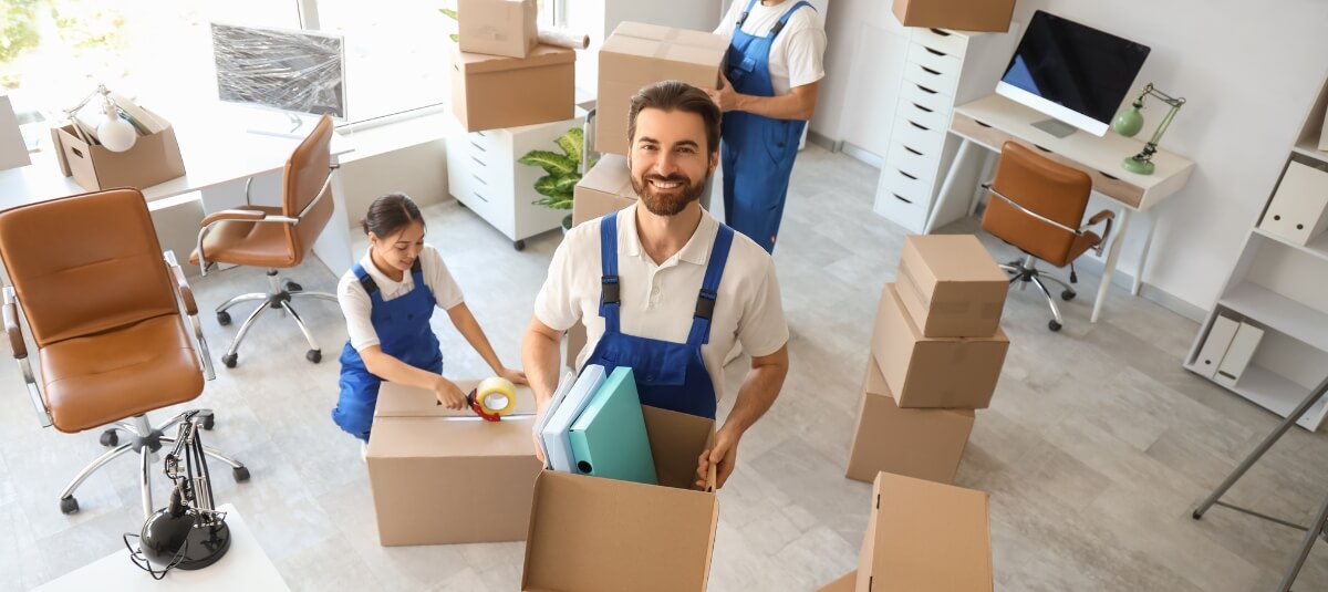 Professional removals team packing boxes during preparation for a long distance move in the UK.