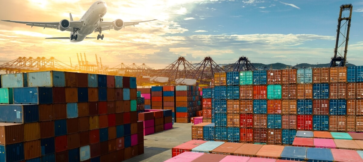 Airplane flying over shipping containers at a UK port – representing international removals and overseas relocation. Airplane flying over shipping containers at a UK port – representing international removals and overseas relocation.