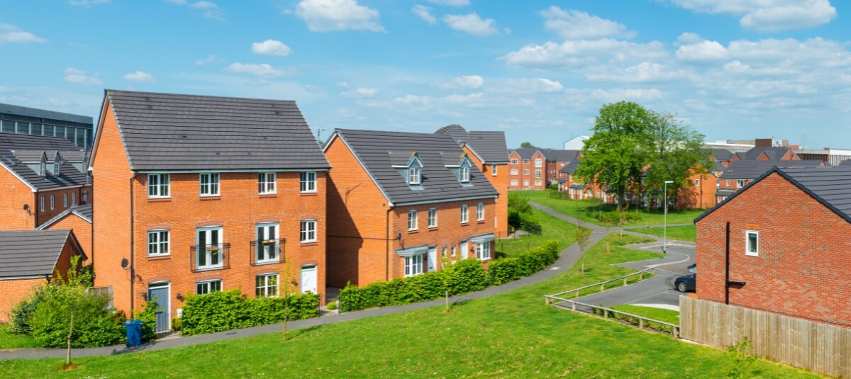 Modern UK housing development on a sunny day, representing new beginnings and moving to a new town in the UK