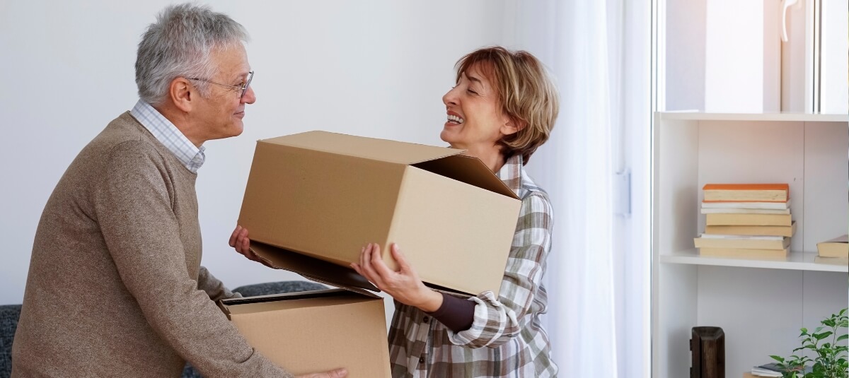 Retired British couple packing boxes before moving to France from the UK. Retired British couple packing boxes before moving to France from the UK.