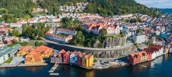 Aerial view of a colorful Norwegian coastal town with traditional buildings, perfect for those considering moving to Norway