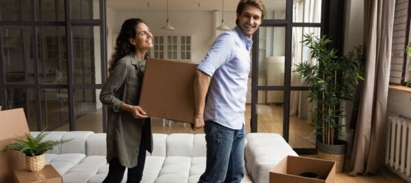 Couple carrying moving boxes into their new home after relocating from the UK to Spain