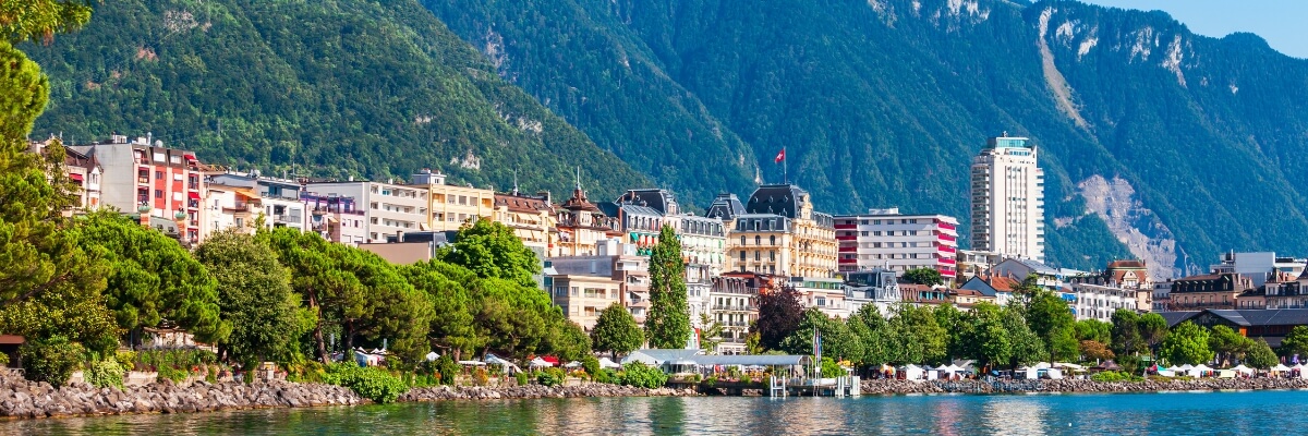 Lakeside town in Switzerland with colourful buildings and Alpine mountains in the background
