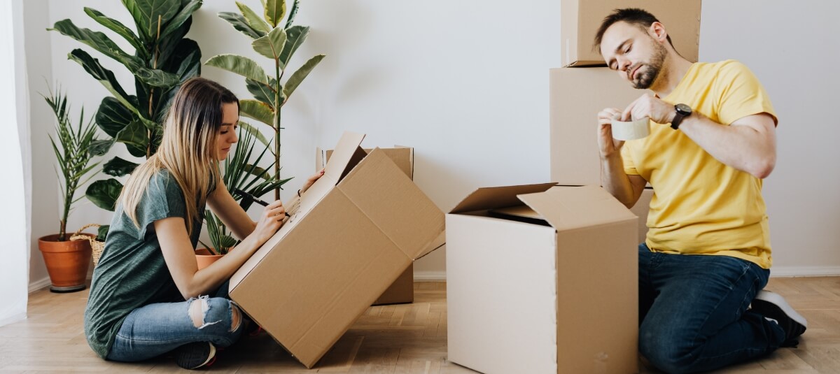 Couple packing boxes for an international move from the UK