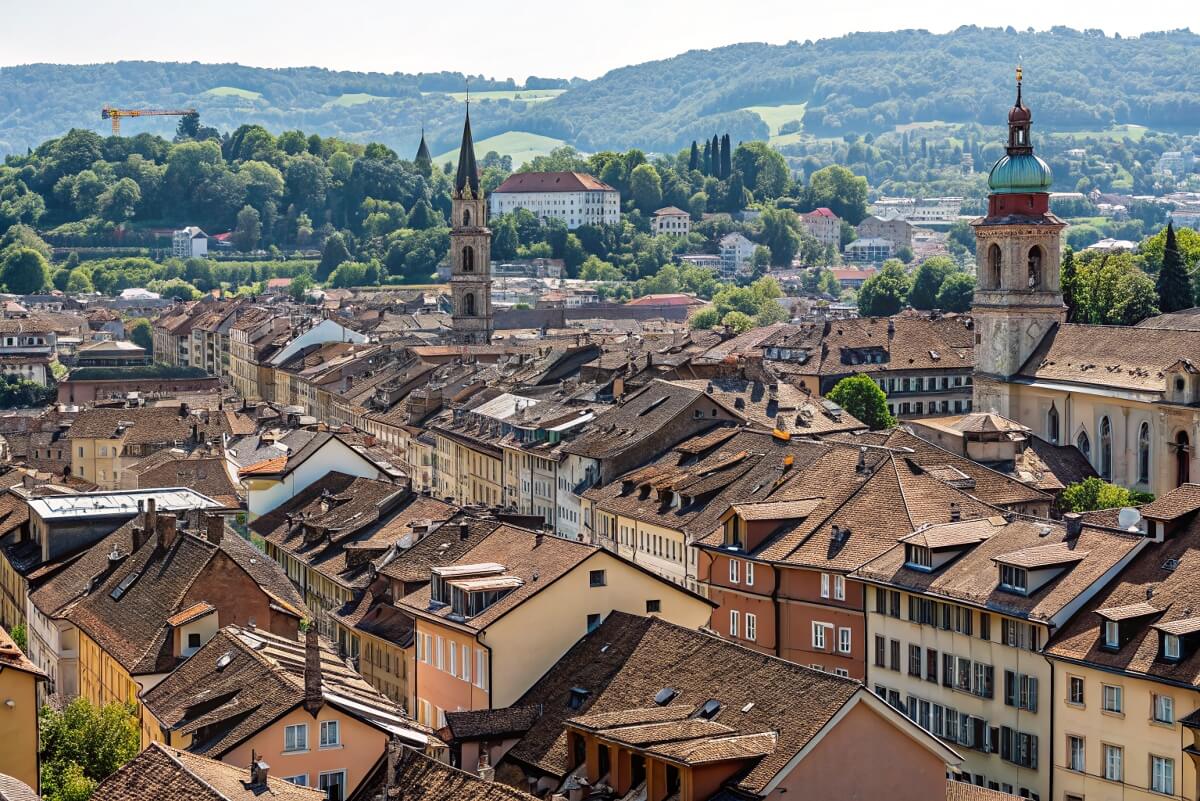 Panoramic view of Winterthur rooftops and church towers with lush green hills in the background – a beautiful Swiss city to move to. Panoramic view of Winterthur rooftops and church towers with lush green hills in the background - a beautiful Swiss city to move to.