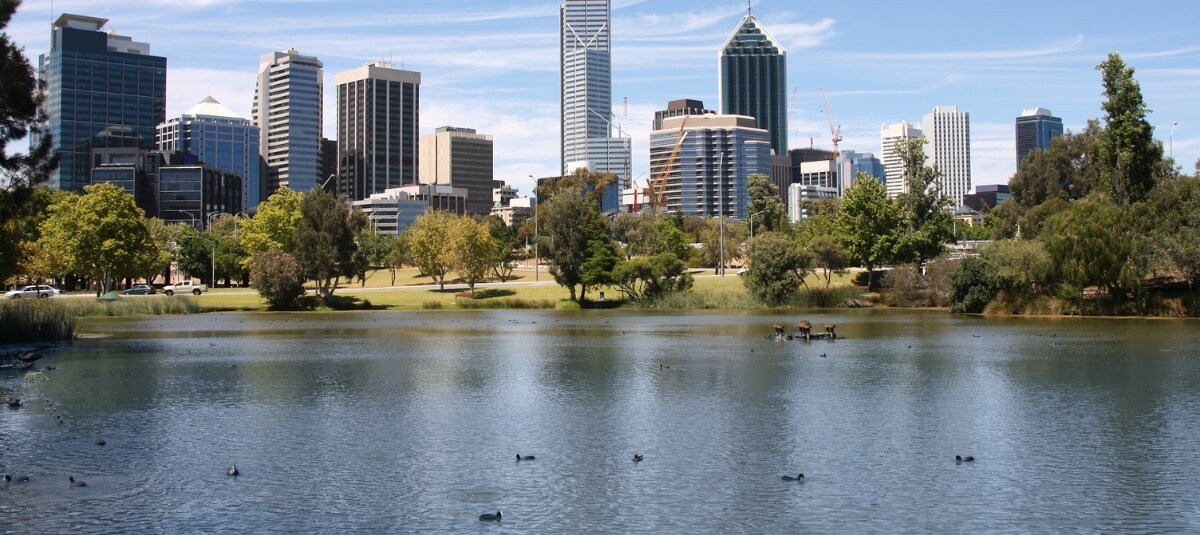 Perth Australia skyline across the water with green parkland