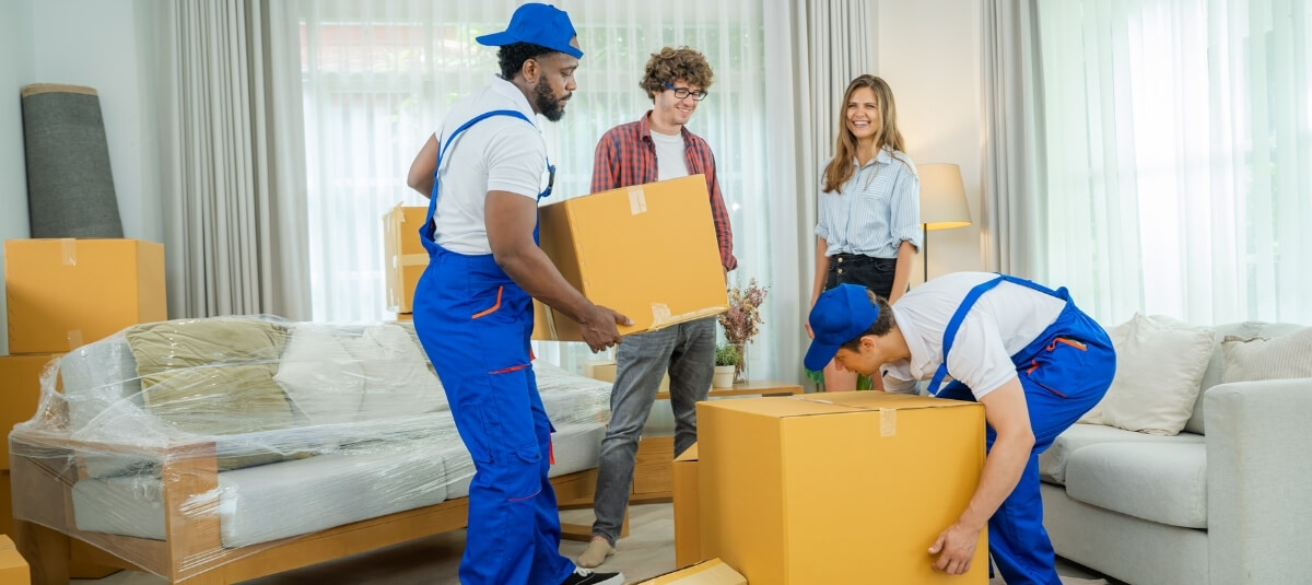 Professional movers packing boxes in a bright living room, representing Total Moving Solutions’ expert removals service for people relocating to Switzerland Professional movers packing boxes in a bright living room, representing Total Moving Solutions’ expert removals service for people relocating to SwitzerlandProfessional movers packing boxes in a bright living room, representing Total Moving Solutions’ expert removals service for people relocating to Switzerland