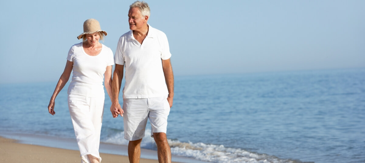 Retired British couple walking on a sunny beach abroad – symbolising retirement lifestyle for UK expatsRetired British couple walking on a sunny beach abroad – symbolising retirement lifestyle for UK expatsRetired British couple walking on a sunny beach abroad – symbolising retirement lifestyle for UK expatsRetired British couple walking on a sunny beach abroad – symbolising retirement lifestyle for UK expats