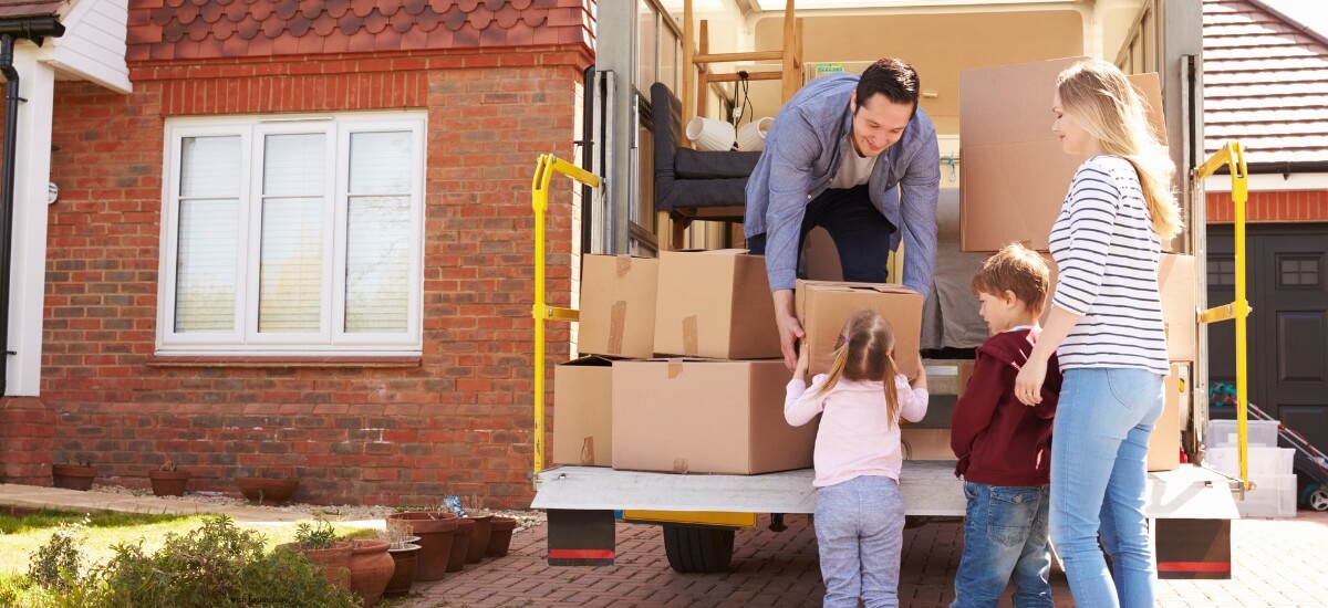 Parents and children unloading moving boxes, representing the ease and care provided by Total Moving Solutions for families relocating to Ireland. Parents and children unloading moving boxes, representing the ease and care provided by Total Moving Solutions for families relocating to Ireland.