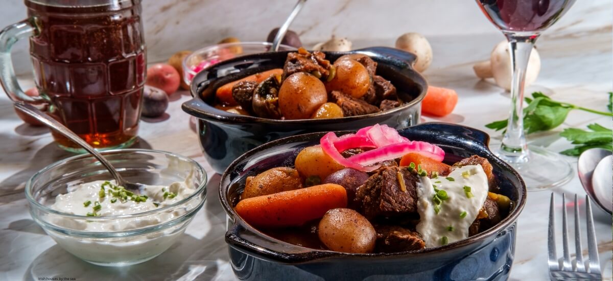Traditional Irish stew with tender beef, potatoes, and carrots, served with a pint of beer and sour cream, capturing the essence of Irish cuisine. Traditional Irish stew with tender beef, potatoes, and carrots, served with a pint of beer and sour cream, capturing the essence of Irish cuisine.