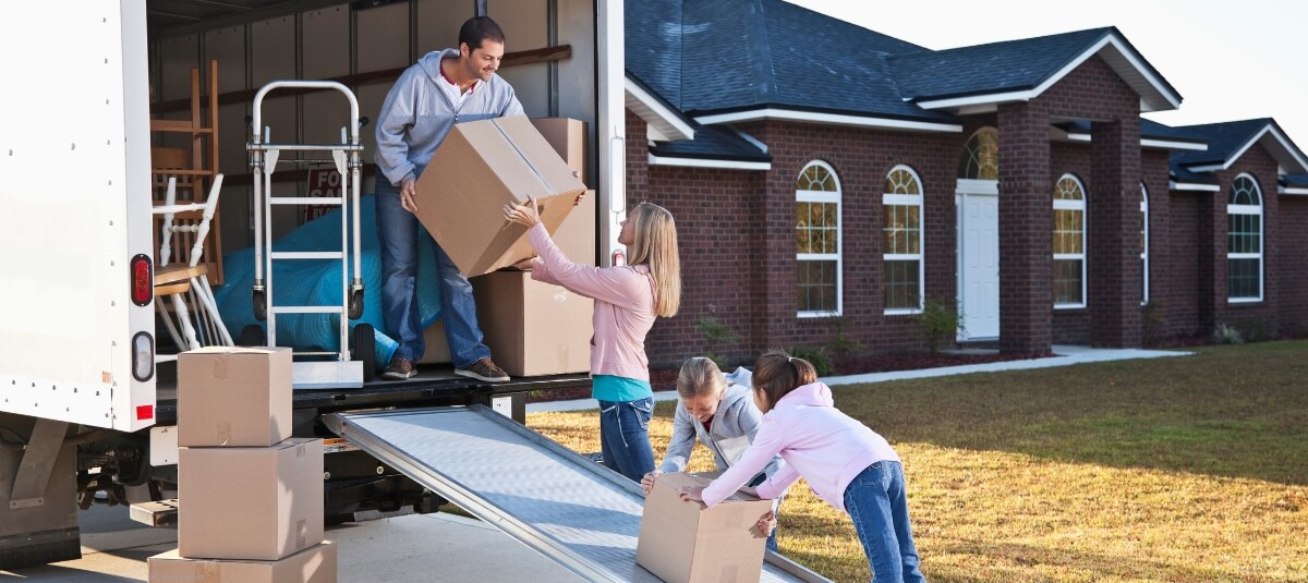 Family loading boxes into removals van for international move with Total Moving Solutions